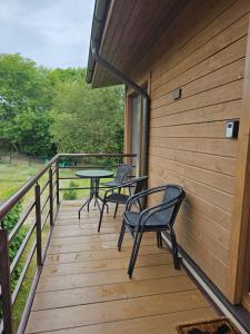 een houten terras met stoelen en tafels erop bij Apartmens LORETA in Šventoji