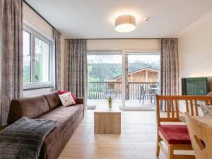 ein Wohnzimmer mit Couch und großem Fenster in der Unterkunft Apart33 Top 1-26 in Haus im Ennstal
