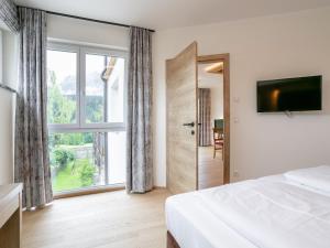 ein Schlafzimmer mit einem Bett und einem großen Fenster in der Unterkunft Apart33 Top 1-26 in Haus im Ennstal