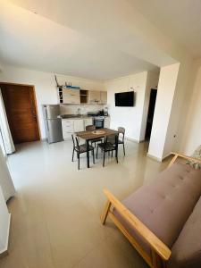 a living room with a table and chairs and a kitchen at Albertina Suites in El Yaque