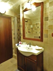 La salle de bains est pourvue d'un lavabo et d'un miroir. dans l'établissement Casetta Donnolo, à Oria