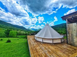 a white tent on a wooden deck with a view at The Hunters Glamping in Ciudanoviţa