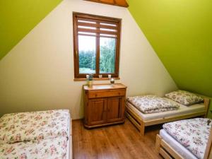 a room with two beds and a sink and a window at Krutyńska Ostoja-Domek in Piecki +2 photos