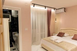 a bedroom with a white bed and a shower at Apartments DoriDitaRejjan in Ulcinj