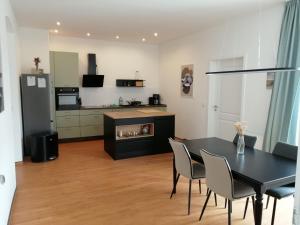 a kitchen and dining room with a black table and chairs at FeWo Luise mit 4-Zimmer, Balkon, 127qm in Görlitz