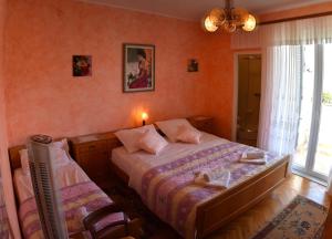 a bedroom with a bed and a chair and a window at Rooms Villa Andreja in Pag