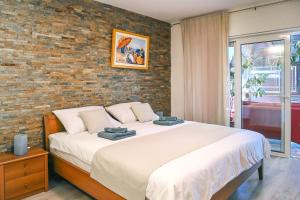 a bedroom with a large bed and a brick wall at Apartmani Kraljevica in Kraljevica +33 photos