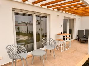 a patio with chairs and tables and a window at D'Felicidade in Caldas da Rainha
