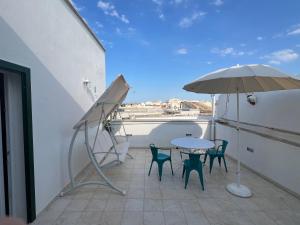 a balcony with a table and chairs and an umbrella at Terrazza Nostromo Francesco in Trani