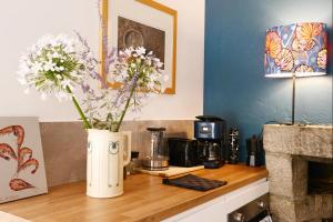 a counter with a vase filled with flowers on it at Ti Melen in Morlaix