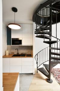 a kitchen with a spiral staircase next to a kitchen at Ti Melen in Morlaix +16 photos