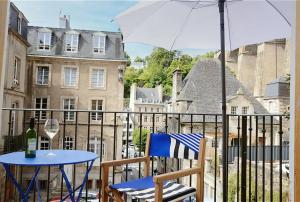 a table and chair on a balcony with an umbrella at Ti Melen in Morlaix