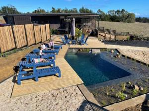 a group of blue chairs next to a swimming pool at CÓMODA CASA FAMILIAR Punta Lobos in Pichilemu
