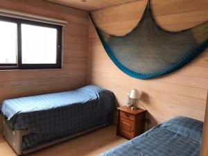 a bedroom with two beds and a net on the wall at CÓMODA CASA FAMILIAR Punta Lobos in Pichilemu +13 photos