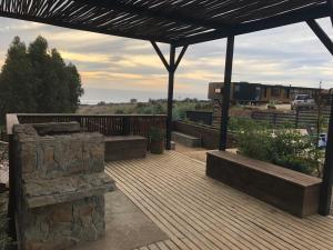 a wooden deck with benches and a roof with a train at CÓMODA CASA FAMILIAR Punta Lobos in Pichilemu