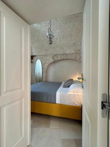 a bedroom with a bed and a brick wall at Montesanto 60 Suite & Relax Alberobello in Alberobello