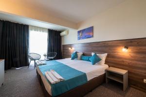 a bedroom with a large bed with a wooden wall at Belitsa Hotel in Primorsko +27 photos