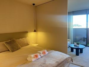 a bedroom with a bed with towels on it at Estudio de diseño con piscina by Gloove in Murcia +16 photos
