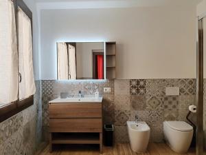 a bathroom with a sink and a toilet and a mirror at S'Arrioleddu in Muravera +18 photos