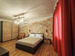 a bedroom with a bed and a brick wall at S'Arrioleddu in Muravera