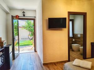 a room with a sliding door with a television on the wall at S'Arrioleddu in Muravera
