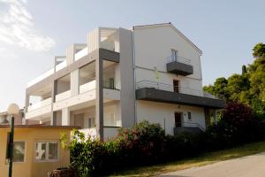 Biały budynek z balkonami na boku w obiekcie Apartmani Mary 2 plus 1 w mieście Kukljica