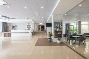 a lobby with a table and chairs in a building at Belitsa Hotel in Primorsko