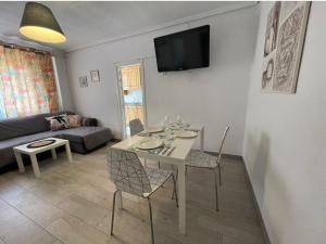 a living room with a table and chairs and a couch at MALVARROSA BEACH FAMILIAR in Valencia