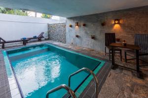 a large swimming pool with a table and a table at Anama by Queens Mount in Tangalle
