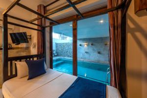 a bedroom with a view of a swimming pool through a window at Anama by Queens Mount in Tangalle