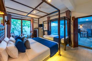 a bedroom with two beds and a large window at Anama by Queens Mount in Tangalle