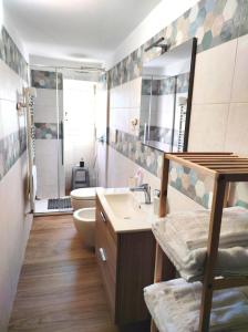 un bagno con lavandino, WC e specchio di Donna Fede a Monopoli