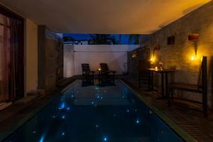 a swimming pool in a room with a table and chairs at Anama by Queens Mount in Tangalle