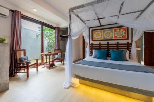 a bedroom with a bed with a canopy at Anama by Queens Mount in Tangalle
