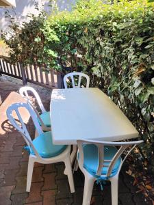 a white table and two chairs sitting next to a hedge at Appartement ARCACHON in Arcachon +8 photos