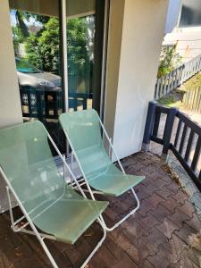two green lawn chairs sitting on a porch at Appartement ARCACHON in Arcachon