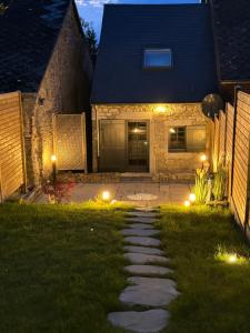 a backyard at night with lights in the grass at La maison d Aurore loft et spa privatif in Couvin