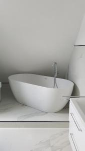 a white bath tub in a white bathroom with a sink at Neue wunderschöne Ferienwohnung direkt im Herzen von Rockenhausen in Rockenhausen