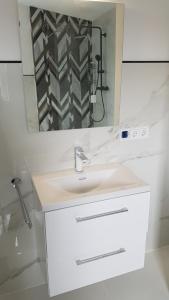 a white bathroom with a sink and a mirror at Neue wunderschöne Ferienwohnung direkt im Herzen von Rockenhausen in Rockenhausen +4 photos
