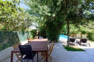 a wooden table and chairs on a patio at Beach & Nature Villa with Amazing Pool by TimeCooler in Setúbal