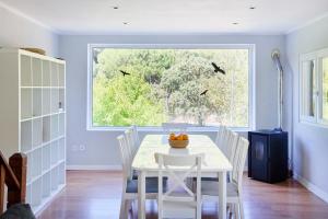 a dining room with a table and chairs and a window at Beach & Nature Villa with Amazing Pool by TimeCooler in Setúbal