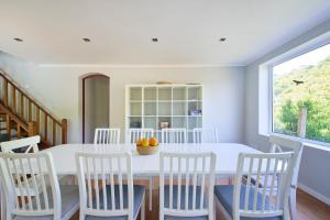 a dining room with a white table and chairs at Beach & Nature Villa with Amazing Pool by TimeCooler in Setúbal