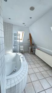 une salle de bain blanche avec une baignoire et une fenêtre dans l'établissement Citywohnung in ruhiger Innenstadtnähe von Coburg, à Cobourg