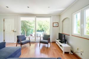a living room with a couch and chairs and a tv at Beach & Nature Villa with Amazing Pool by TimeCooler in Setúbal