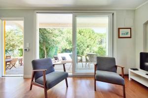 a living room with two chairs and a television at Beach & Nature Villa with Amazing Pool by TimeCooler in Setúbal