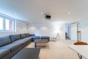 Una sala de estar con un sofá azul y una mesa. en Villa Foch - 200m2 - Disneyland - Expo Park - Paris CDG, en Aulnay-sous-Bois