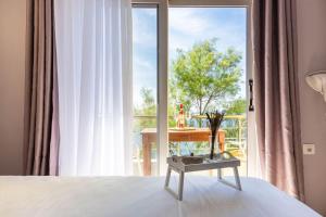 a bedroom with a bed with a table in front of a window at Potam'Sea Bliss 4 - Beach Front, Sun Beds & Parking in Himare +24 photos