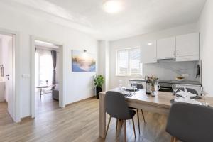Una cocina y un comedor con mesa y sillas. en Maloa One Bedroom 2, en Smokvica