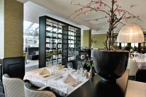 a dining room with a table with a plant on it at Van der Valk Hotel Nazareth-Gent in Nazareth