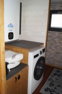 a washer and dryer in a small room at SPA & Tiny house à la campagne in La Boissière